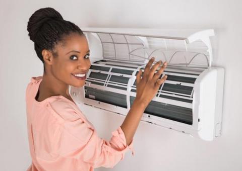 woman opening air conditioner at home